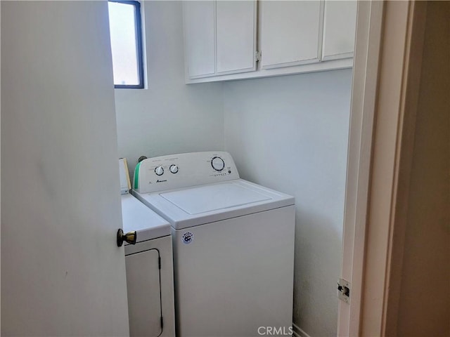 clothes washing area featuring washer and dryer and cabinets