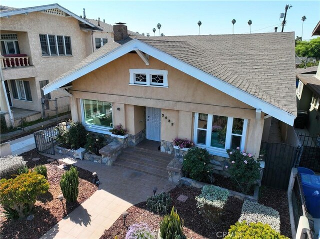 3959 Denker Ave, Los Angeles, CA 90062 - view of front facade with stucco siding, roof with shingles, a gate, and a chimney