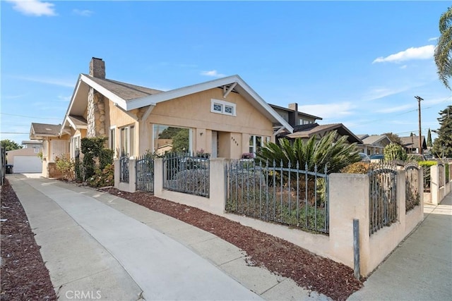 3959 Denker Ave, Los Angeles, CA 90062 - bungalow-style home featuring a chimney, a fenced front yard, stone siding, concrete driveway, and a gate