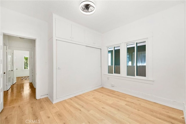 3959 Denker Ave, Los Angeles, CA 90062 - unfurnished bedroom featuring light wood finished floors, baseboards, and a closet