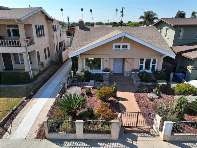 3959 Denker Ave, Los Angeles, CA 90062 - view of front of property featuring a gate, a fenced front yard, stucco siding, and roof with shingles