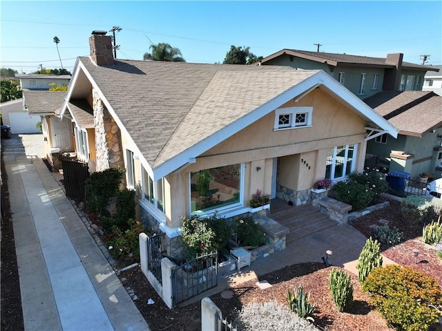 3959 Denker Ave, Los Angeles, CA 90062 - view of front of home with stone siding, roof with shingles, a chimney, and stucco siding