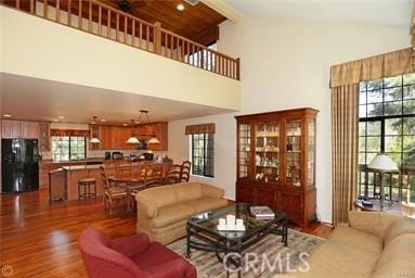 living room with hardwood / wood-style floors and high vaulted ceiling