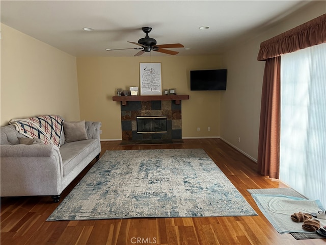 living room featuring hardwood / wood-style floors, a fireplace, and ceiling fan