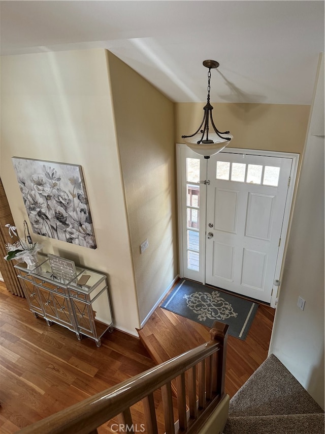 foyer entrance featuring lofted ceiling and dark hardwood / wood-style floors