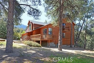 rear view of house featuring a wooden deck