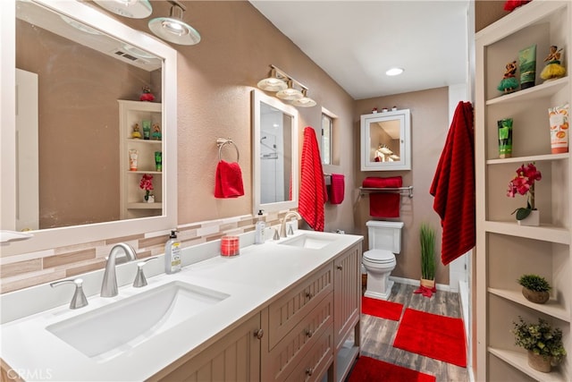 bathroom with backsplash, vanity, and toilet