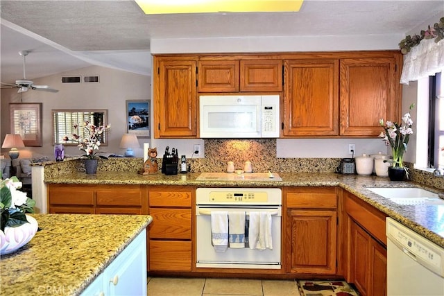 kitchen featuring vaulted ceiling, ceiling fan, a healthy amount of sunlight, and white appliances