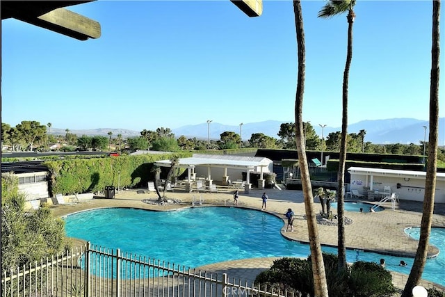 view of swimming pool with a mountain view and a patio area