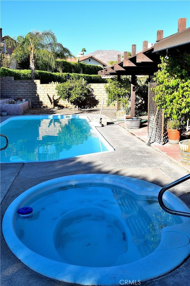 view of pool featuring an in ground hot tub