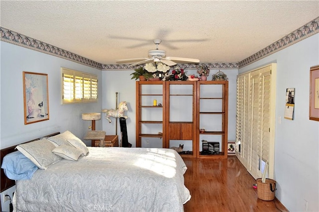 bedroom featuring a textured ceiling, ceiling fan, and dark wood-type flooring