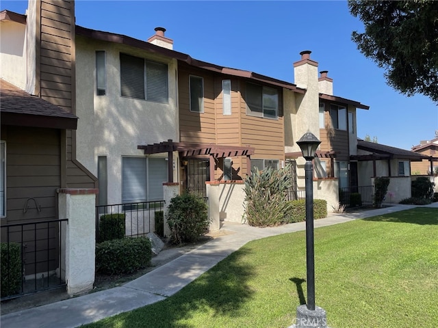 view of property with a front yard and a pergola