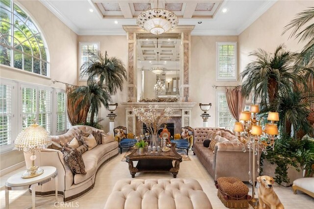 interior space featuring ornamental molding, a high end fireplace, coffered ceiling, a high ceiling, and a notable chandelier