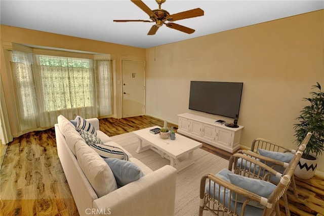 living room featuring light hardwood / wood-style flooring and ceiling fan