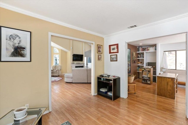 interior space featuring light wood-type flooring and crown molding