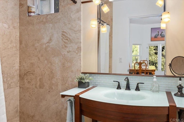 bathroom featuring vanity and tasteful backsplash