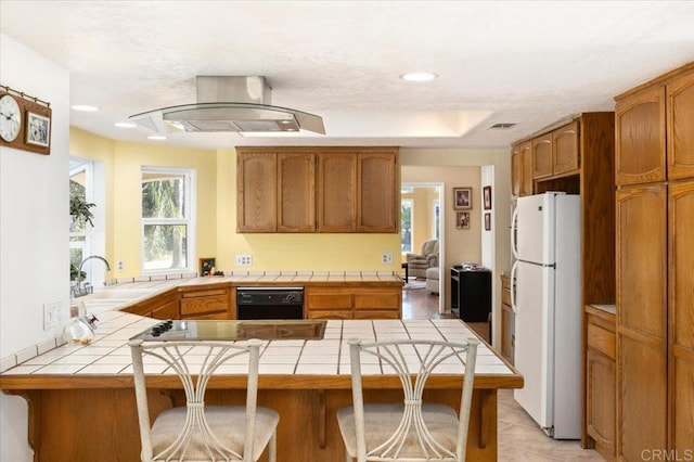 kitchen featuring black dishwasher, kitchen peninsula, tile countertops, and white fridge