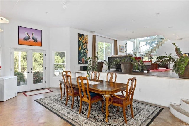 dining space featuring french doors, plenty of natural light, and concrete floors