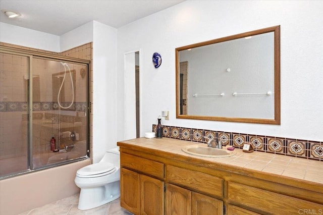 full bathroom featuring tile patterned flooring, enclosed tub / shower combo, vanity, and toilet