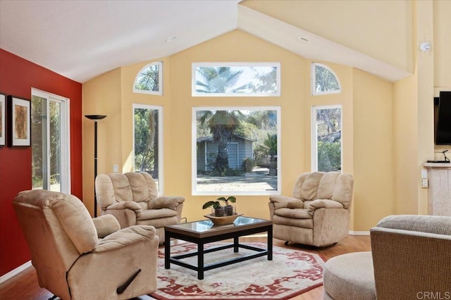 living room with vaulted ceiling, plenty of natural light, and hardwood / wood-style floors