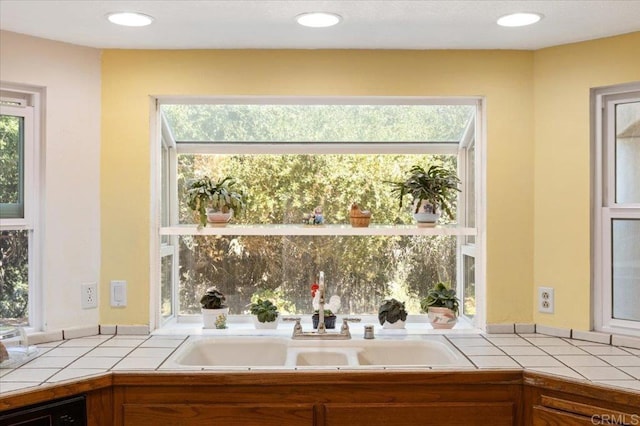 kitchen with plenty of natural light, sink, and tile countertops