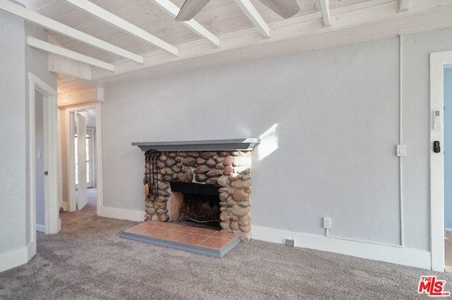 living room with beam ceiling, carpet floors, and a stone fireplace