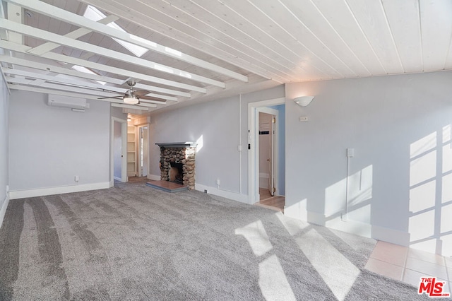 unfurnished living room featuring a stone fireplace, beam ceiling, light carpet, and ceiling fan