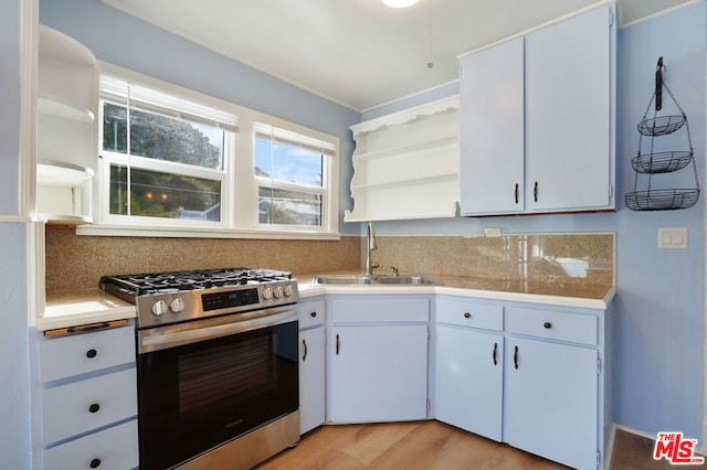 kitchen with gas range, sink, and white cabinetry