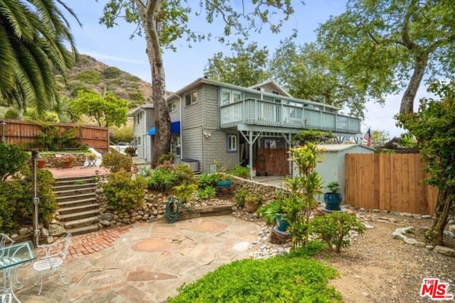 back of house with a mountain view and a patio area