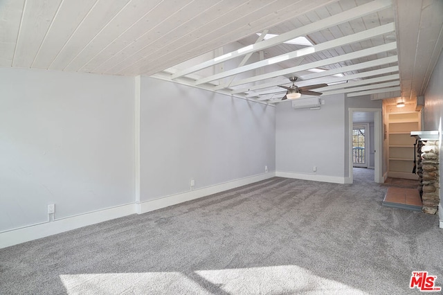 spare room with beam ceiling, carpet, ceiling fan, and a wall mounted AC