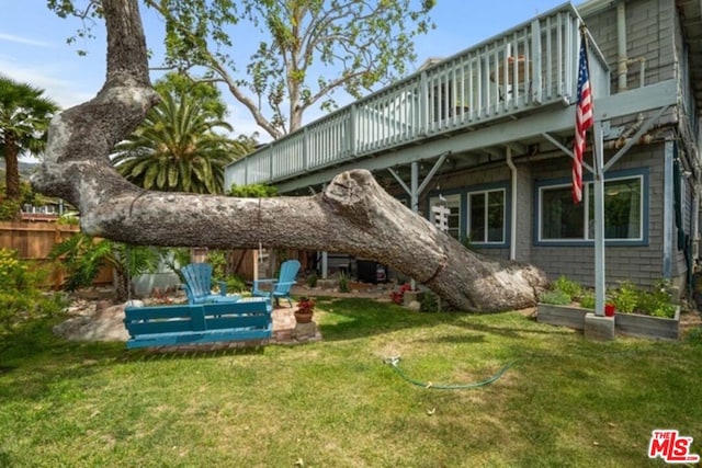 rear view of house featuring a lawn and a deck