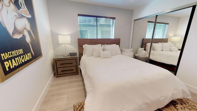 bedroom featuring a closet, multiple windows, and light hardwood / wood-style flooring