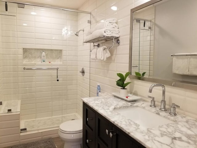 bathroom with vanity, a shower with shower door, and toilet