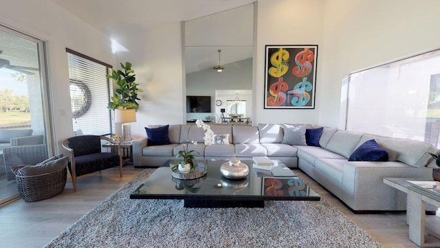 living room with high vaulted ceiling and light wood-type flooring