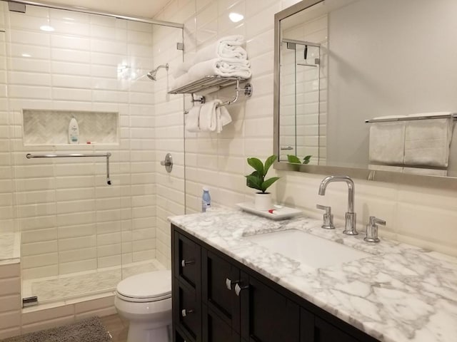 bathroom with walk in shower, vanity, and toilet