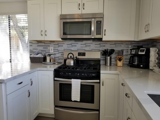 kitchen with stainless steel appliances, tasteful backsplash, and white cabinetry