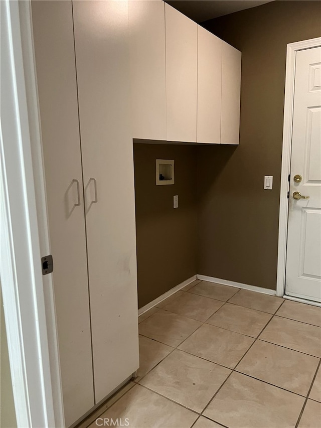 laundry room featuring hookup for a washing machine, cabinets, and light tile patterned flooring