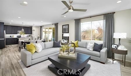 living room featuring light hardwood / wood-style flooring and ceiling fan