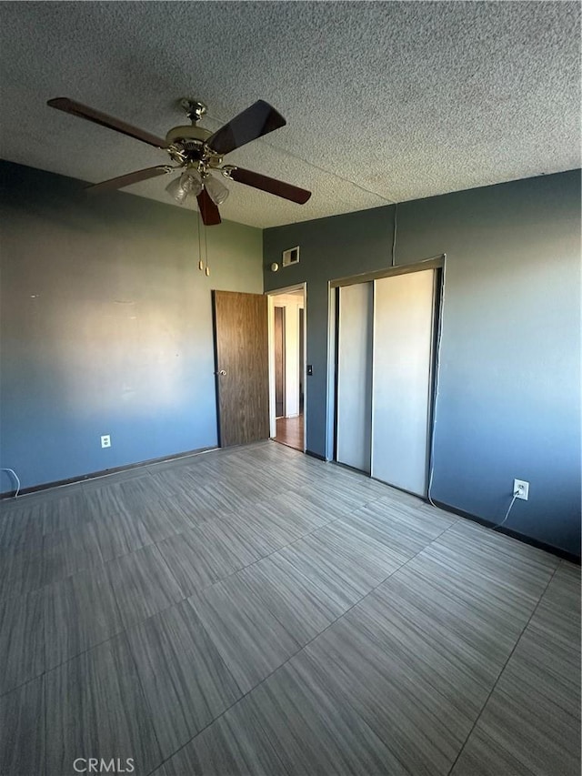 unfurnished bedroom with ceiling fan, a closet, and a textured ceiling