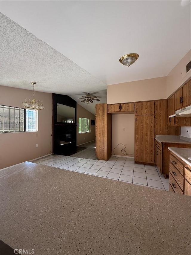 kitchen with pendant lighting, light tile patterned floors, ceiling fan with notable chandelier, and a wealth of natural light