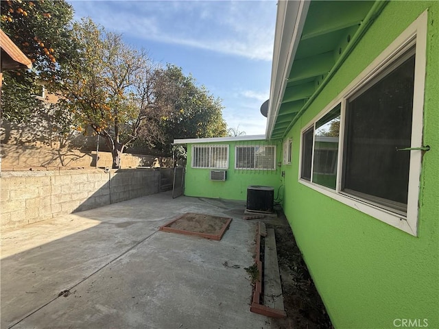 exterior space featuring a wall mounted AC, cooling unit, and a patio area