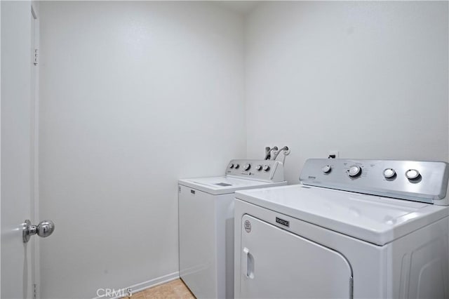 laundry room featuring washing machine and dryer and light tile patterned floors