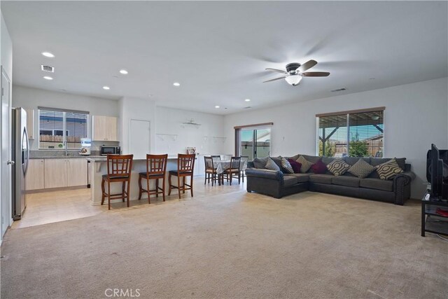 carpeted living room featuring ceiling fan