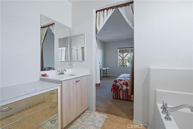 bathroom featuring tile patterned flooring, vanity, and a tub