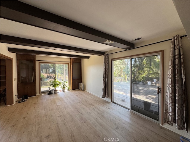 interior space with light wood-type flooring, beam ceiling, and a healthy amount of sunlight