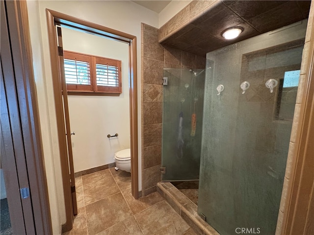 bathroom featuring a shower with door, tile patterned floors, and toilet