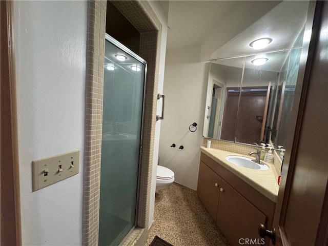 bathroom with a shower with door, vanity, and toilet