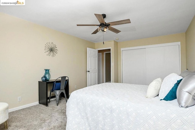 bedroom with a closet, ceiling fan, and light colored carpet