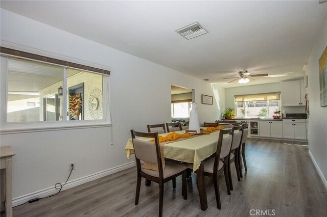 dining area featuring dark wood-type flooring, beverage cooler, and ceiling fan