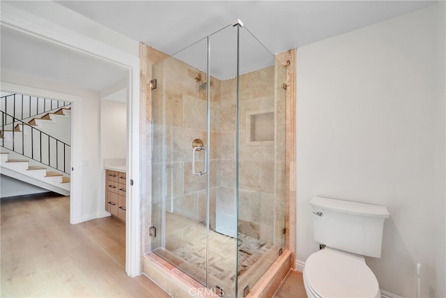 bathroom featuring walk in shower, vanity, hardwood / wood-style floors, and toilet